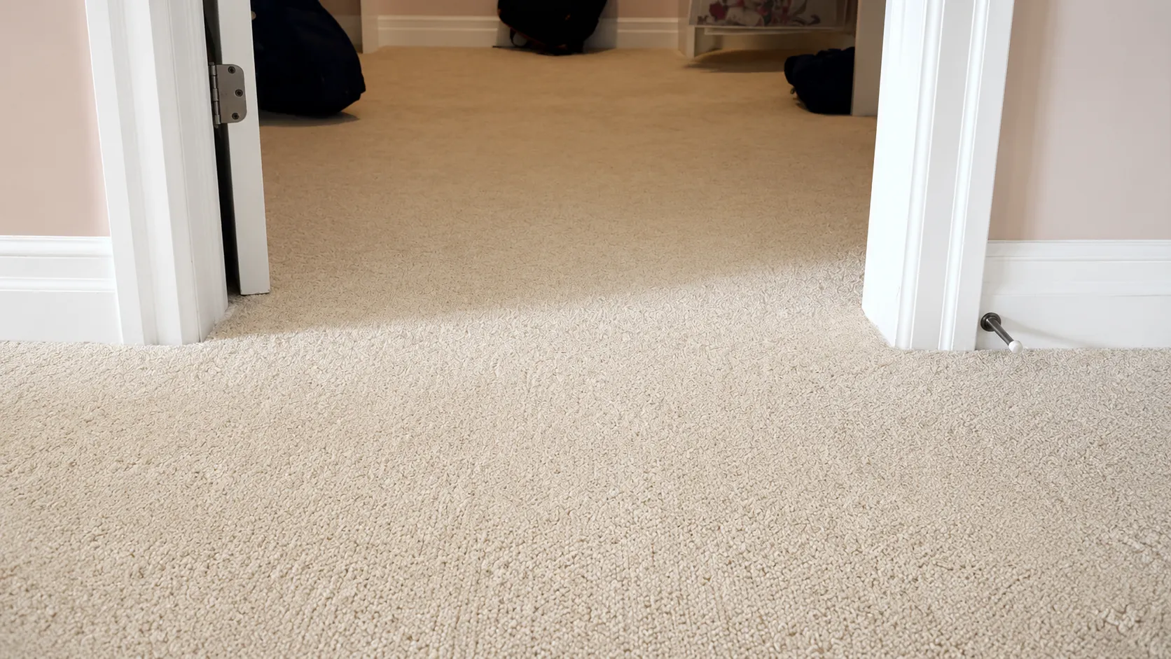 Beige loop-pile carpet running through a doorway between two rooms